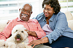 Couple spending time with dog on couch