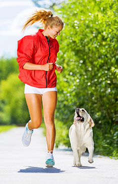 Girl and dog running in park